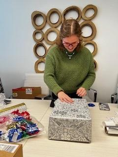 A Trial Pro team member wrapping a holiday gift for an Angel Family.