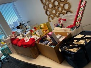 Donated holiday gifts and wrapping supplies collected in the Trial Pro office.