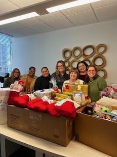 Trial Pro staff standing behind collected Salvation Army Angel Tree donations.