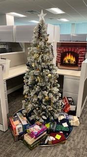 A decorated Christmas tree surrounded by gifts for a Salvation Army Angel Family.